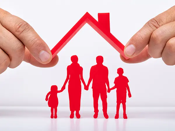 Hands holding a small roof over a silhouette of a family