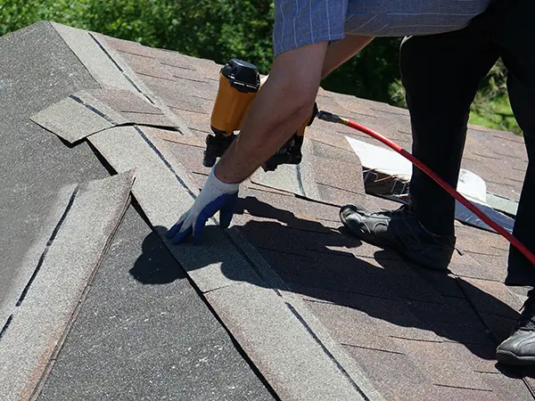 Roofer installing new shingles on roof